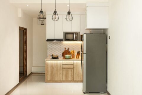 A very small, clean apartment kitchen with limited counter space and basic appliances, showing a single burner and a few neatly organized items.