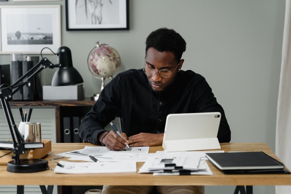 A small business owner reviewing a tablet displaying meeting notes and action items, looking focused.