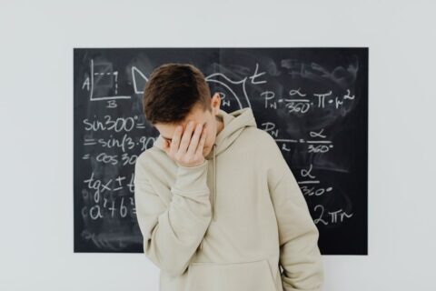 A person looking puzzled and slightly frustrated at a computer screen displaying various AI chatbot interfaces, symbolizing the confusion users face when choosing an AI tool.