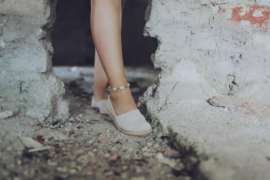 A comparison table of humid city summer styles, featuring a model elegantly posing in a light, flowing summer dress with espadrille sandals and a straw bag, perfect for a French aesthetic in a warm urban environment.