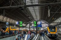 A busy train station concourse with people and trains, symbolizing travel connections for day trips.
