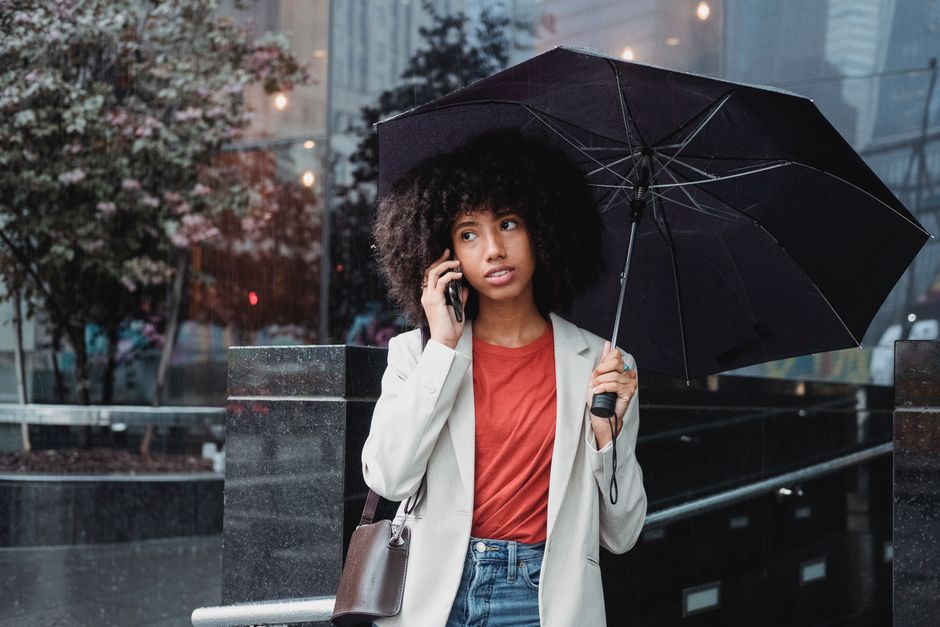 A traveler navigating a charming European city lane, wearing breathable and water-resistant clothing, prepared for sun, rain, and wind.