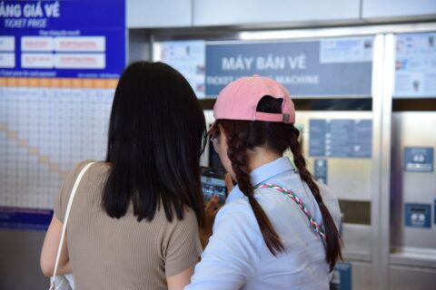 A tourist at a ticket machine in a metro station, purchasing a transit pass.