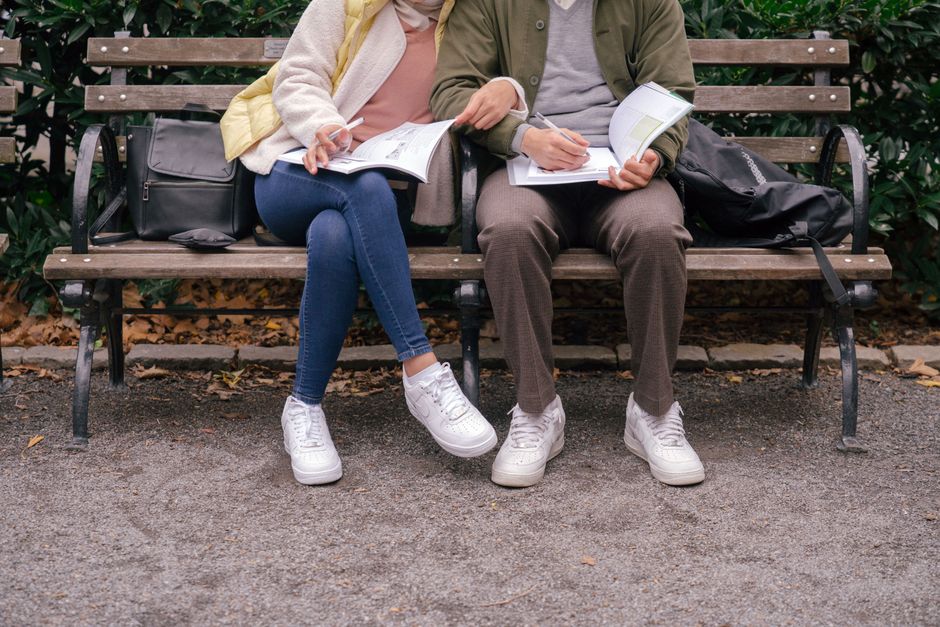 Individuals enjoying a sunny afternoon in a bustling city park, some reading on benches, others strolling, illustrating a vibrant urban green space becoming part of a daily routine.
