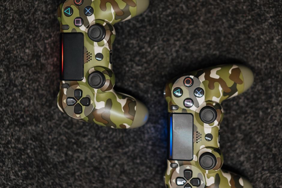 A close-up shot of various video game controllers (PlayStation, Xbox, Nintendo Switch) stacked neatly, symbolizing choice and variety in gaming options.